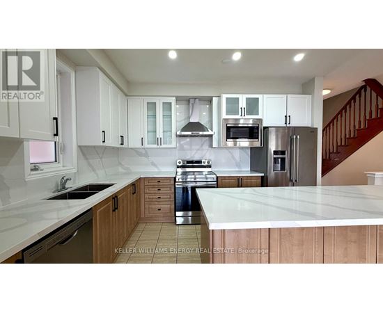 A kitchen with white cabinets and a stainless steel refrigerator.