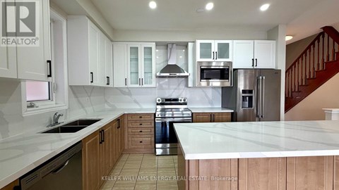 A kitchen with white cabinets and a stainless steel refrigerator.