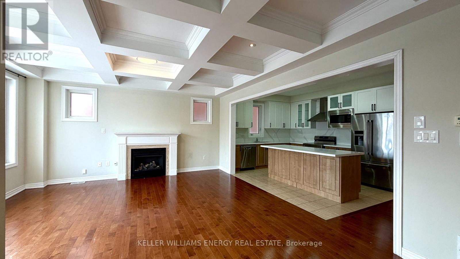A spacious living room with hardwood floors and a fireplace.