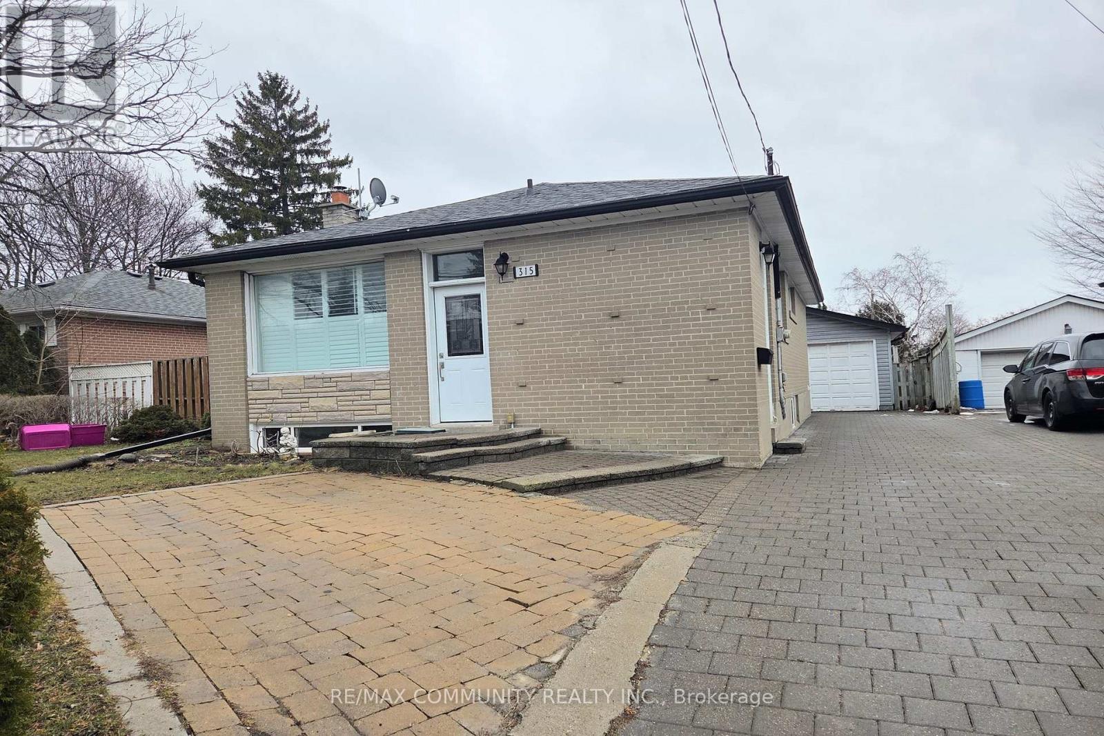 A small house with a driveway in front of it.