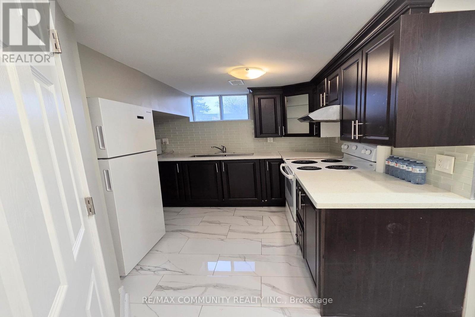A kitchen with white cabinets and a white refrigerator.