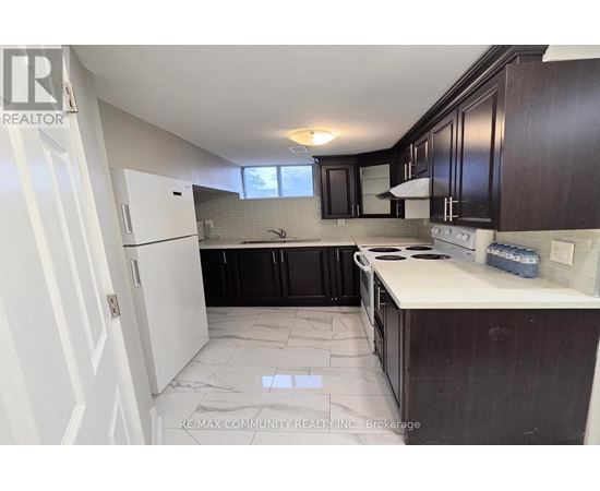 A kitchen with white cabinets and a white refrigerator.