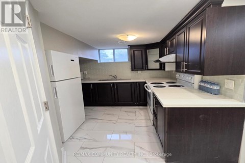 A kitchen with white cabinets and a white refrigerator.