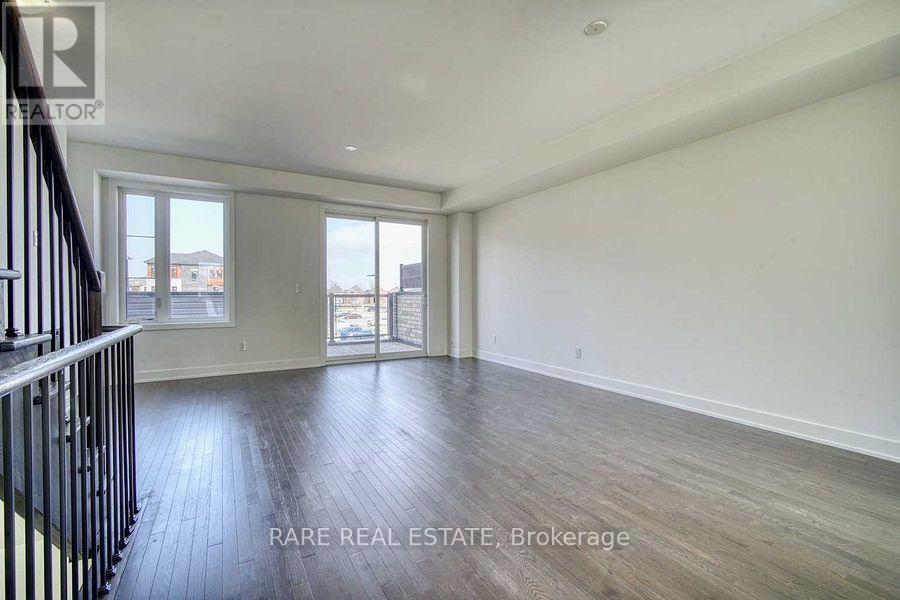 A spacious room with wooden flooring and a large window overlooking a cityscape.