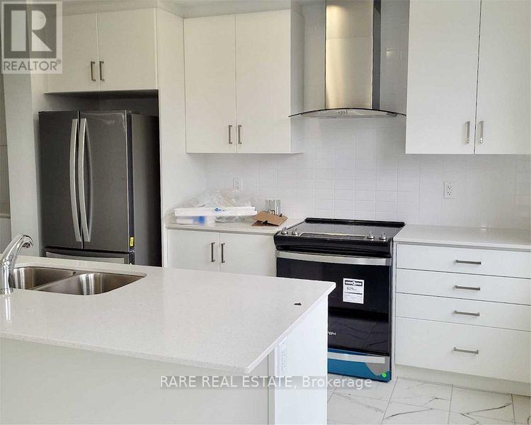 A kitchen with white cabinets and a stainless steel refrigerator.