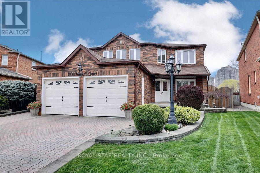 A house with a brick facade and a white garage door is for sale.