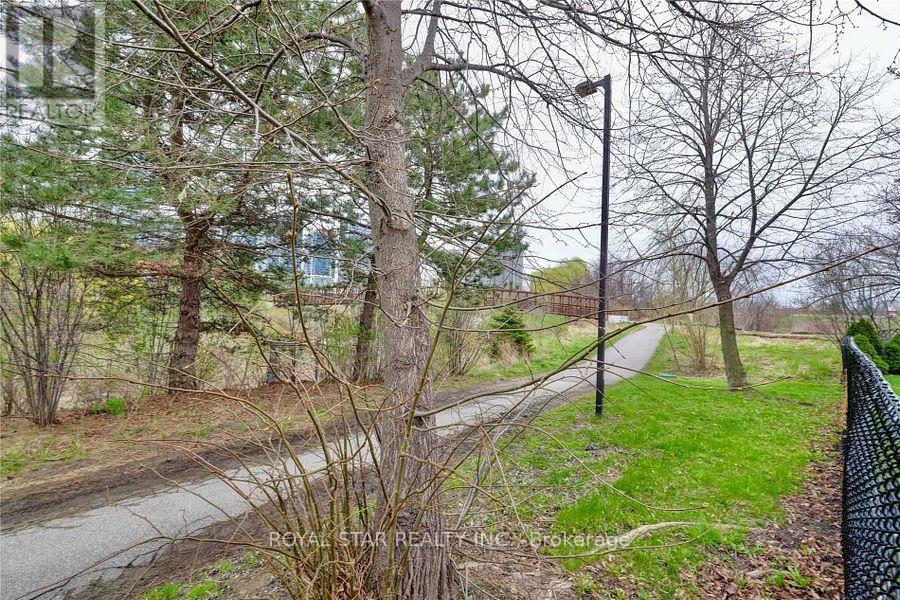 A road with a fence on the right side and trees on the left.