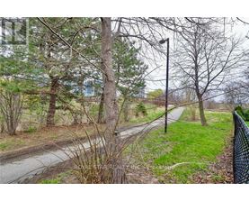 A road with a fence on the right side and trees on the left.