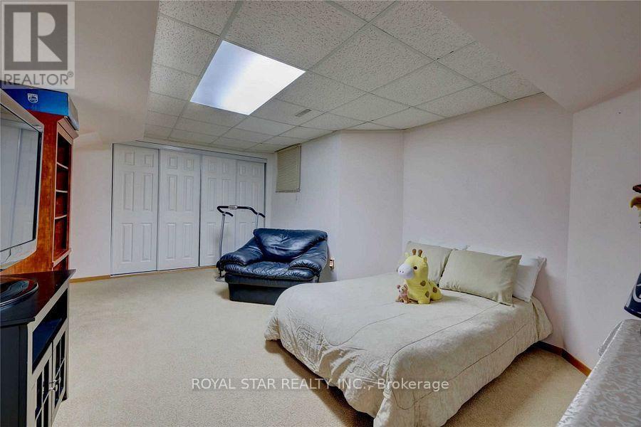 A bedroom with a bed, a chair, and a teddy bear on the bed.