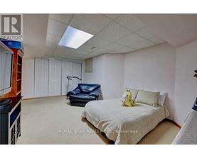 A bedroom with a bed, a chair, and a teddy bear on the bed.