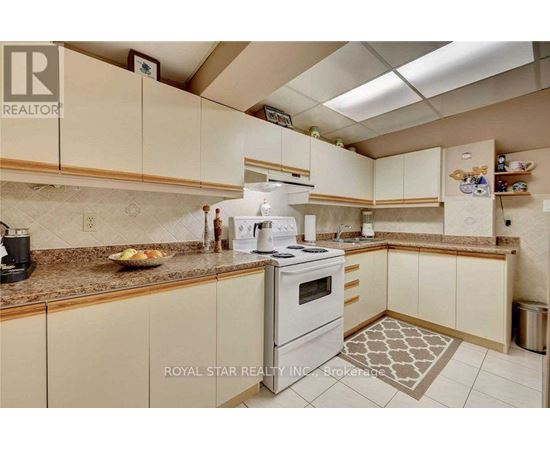 A kitchen with a white stove and cabinets.