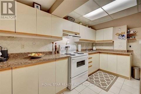 A kitchen with a white stove and cabinets.