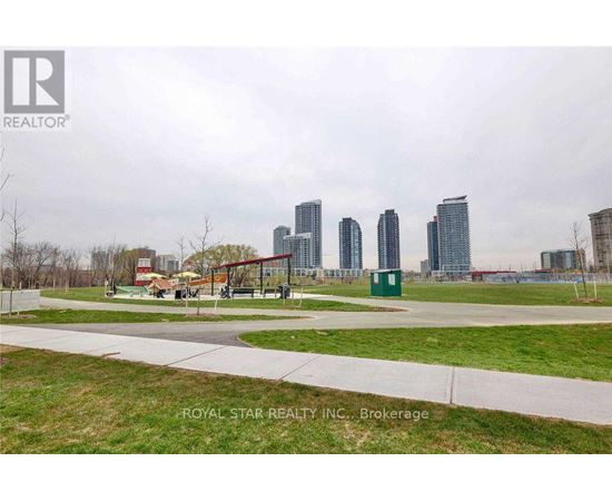 A park with a playground and a city skyline in the background.