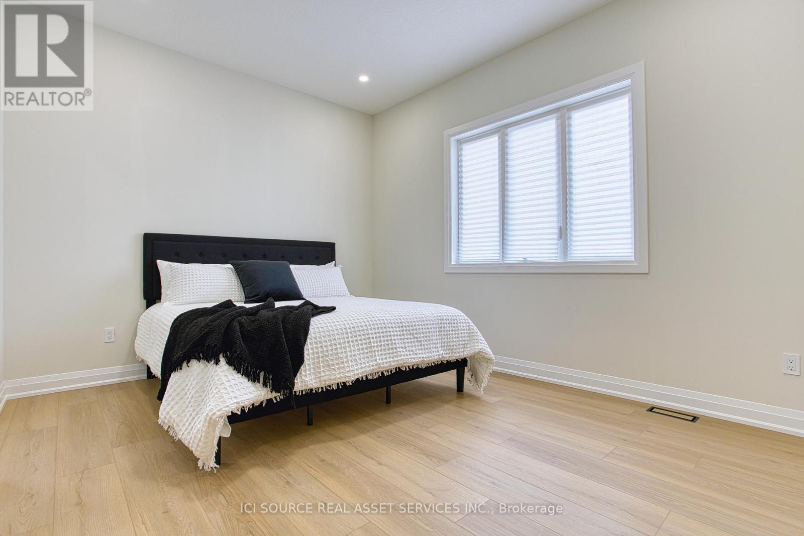 A bedroom with a bed, pillows, and a blanket.