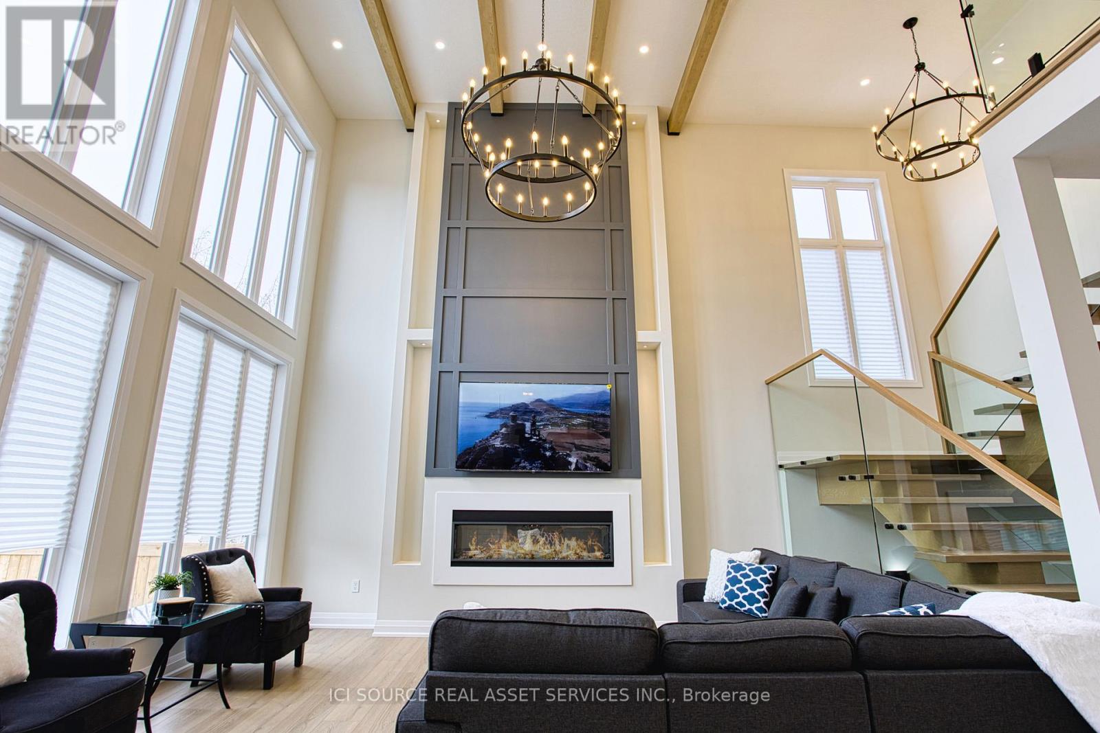 A living room with a fireplace and a television mounted above it.