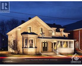 A house with a sign that says RE/MAX Hallmark Realty Group Brokerage.