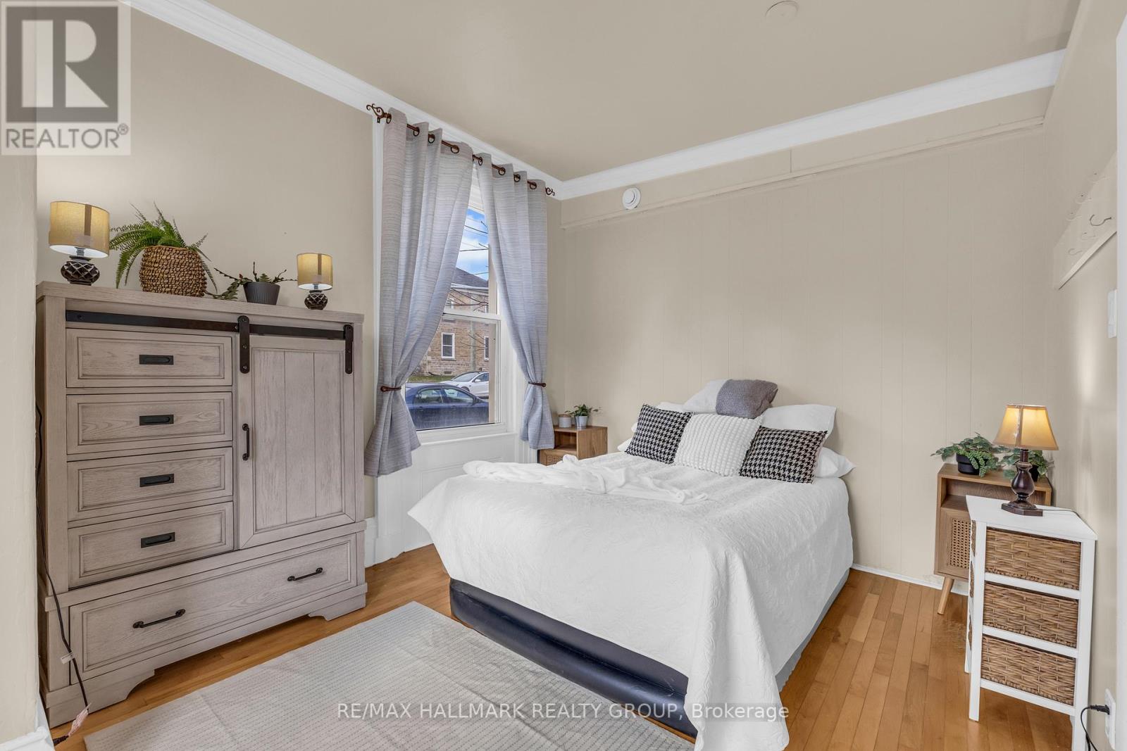 A bedroom with a large bed, a nightstand, and a dresser.