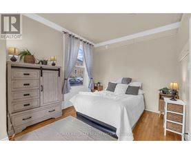 A bedroom with a large bed, a nightstand, and a dresser.