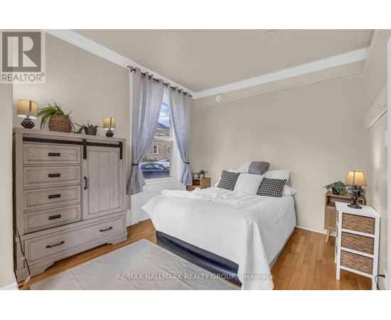 A bedroom with a large bed, a nightstand, and a dresser.