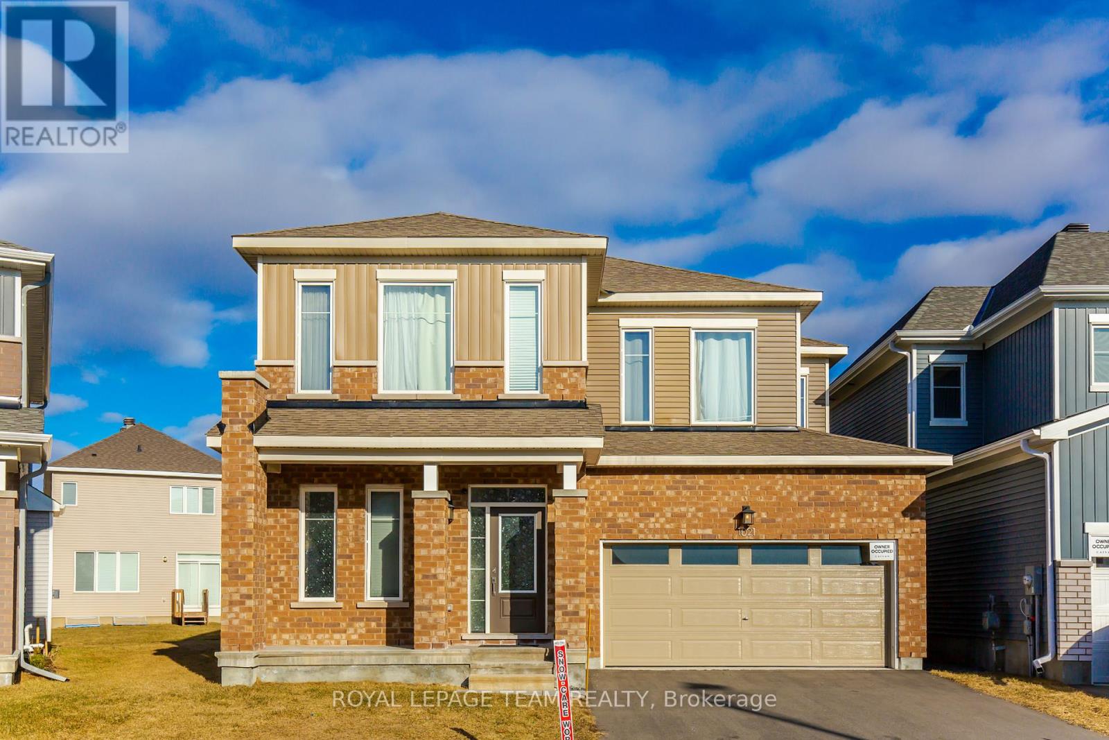 A house with a brick facade and a garage is for sale.