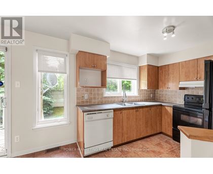 A kitchen with wooden cabinets and a black oven.