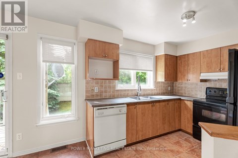 A kitchen with wooden cabinets and a black oven.