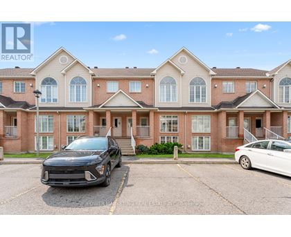 A black car is parked in front of a building with a sign that reads "REALTOR".