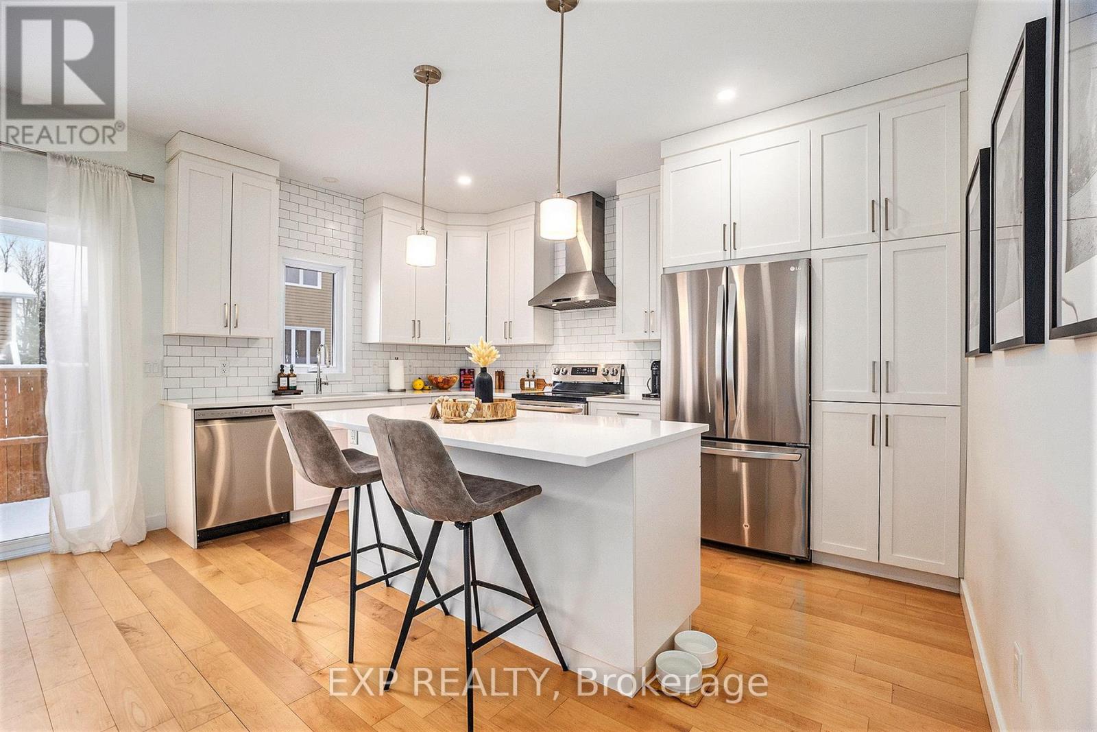 A kitchen with white cabinets and a wooden floor.