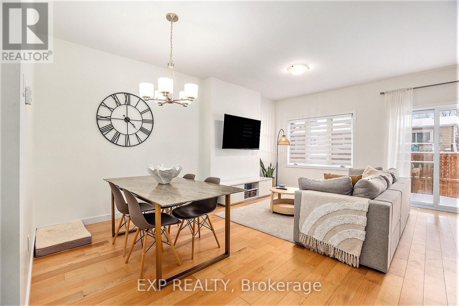 A dining room with a table set for four and a couch with a throw pillow.