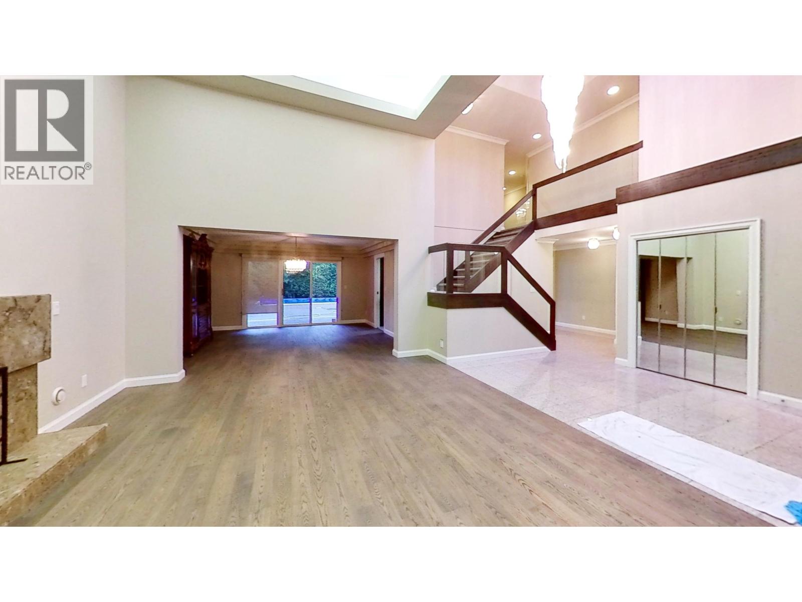 A spacious room with a staircase and a skylight.