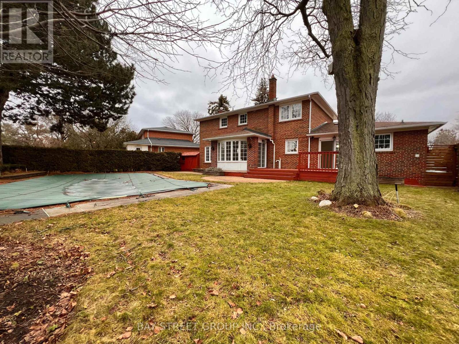 A house with a red brick exterior and a green lawn.