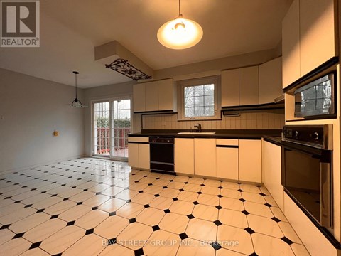 A kitchen with black and white tiles on the floor.