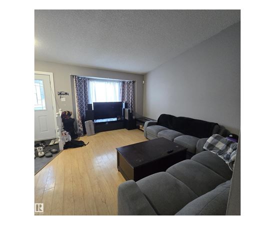 A living room with a grey couch and a black coffee table.