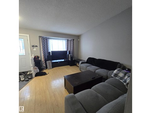 A living room with a grey couch and a black coffee table.