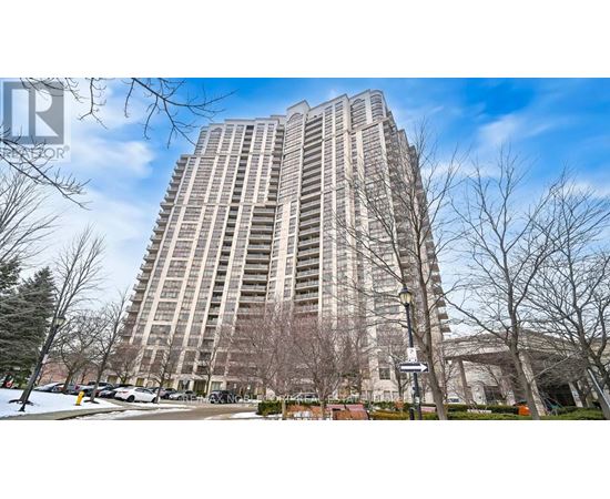 A tall residential building with a parking lot in front.