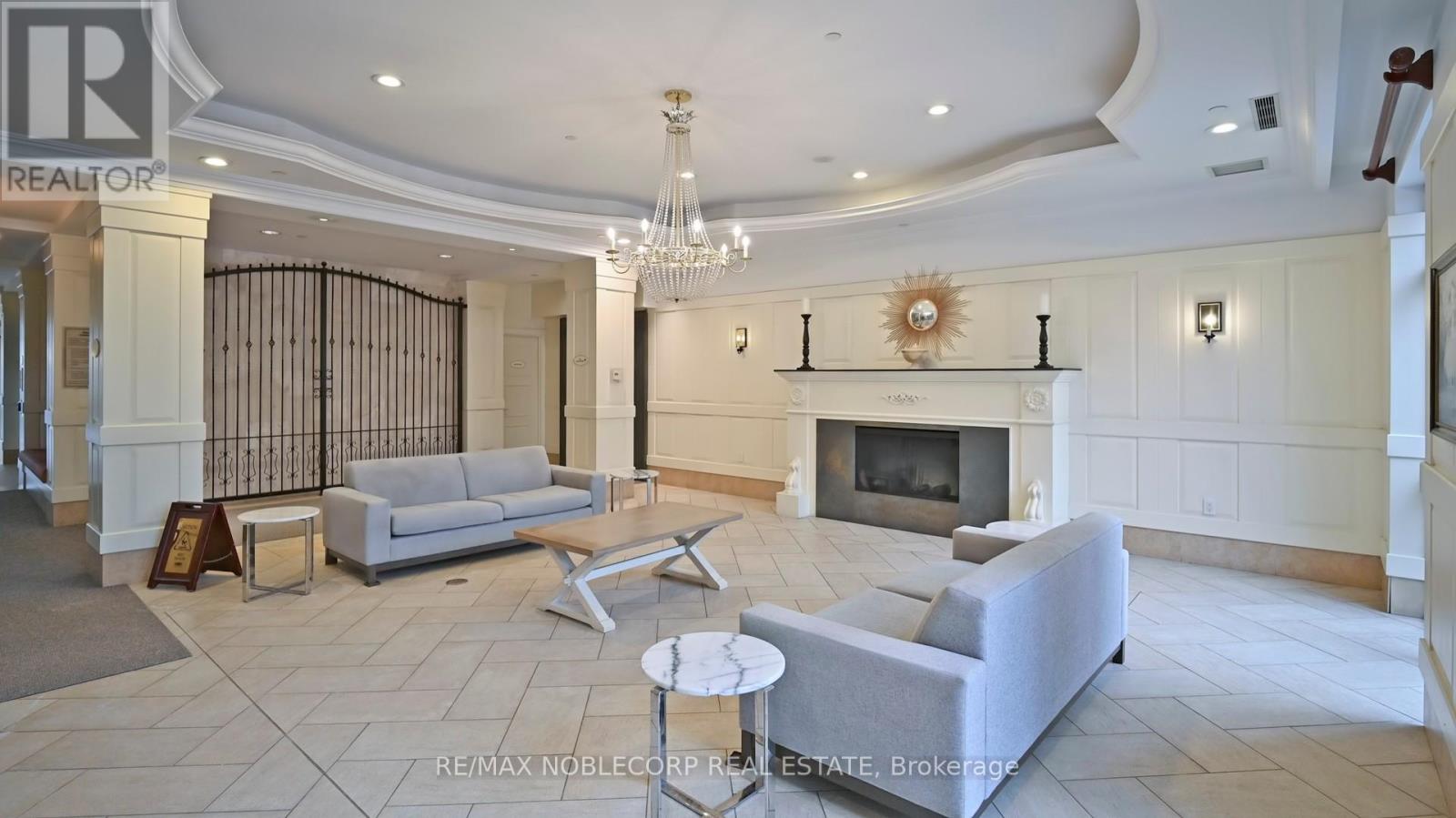 A living room with a fireplace and a chandelier.