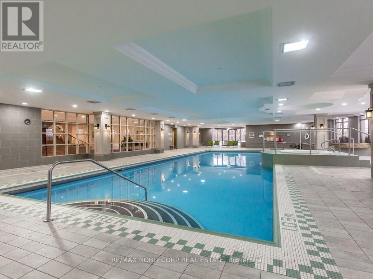A large indoor swimming pool with a tiled edge and a metal ladder.