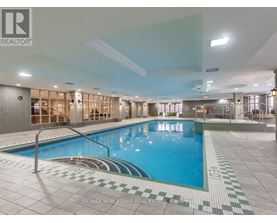 A large indoor swimming pool with a tiled edge and a metal ladder.