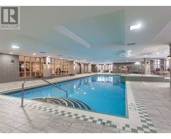 A large indoor swimming pool with a tiled edge and a metal ladder.