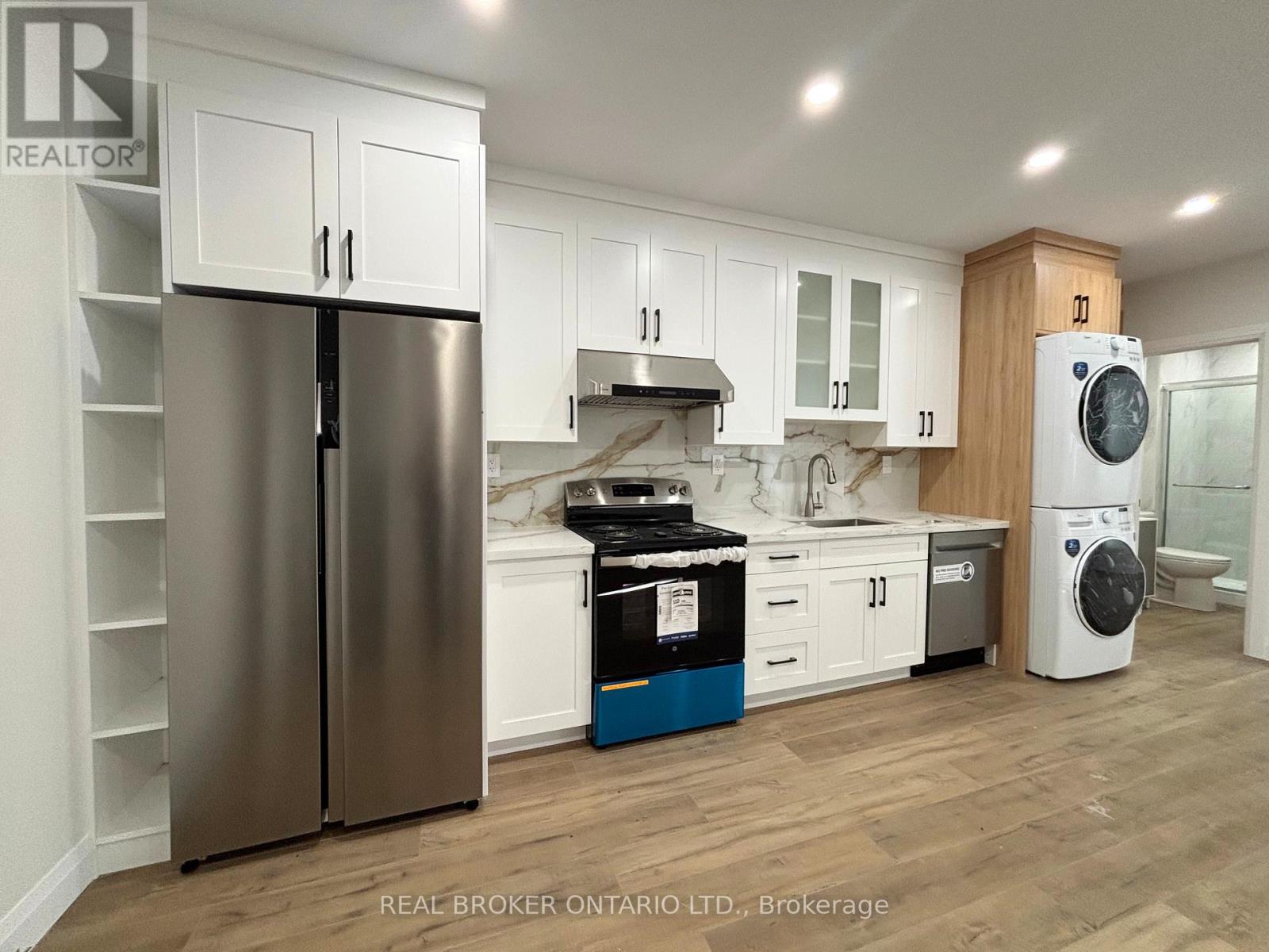 A modern kitchen with a stainless steel refrigerator and wooden cabinets.