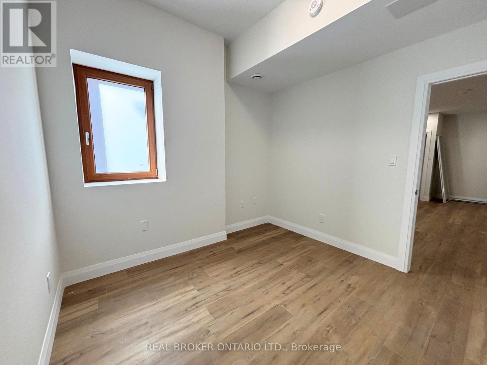 A room with wooden flooring and a window.