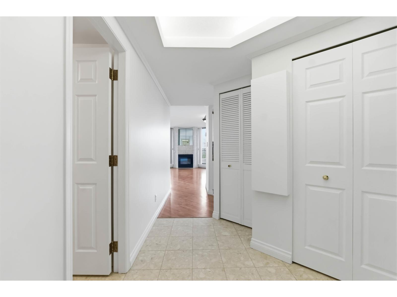A hallway with white doors and a tiled floor.