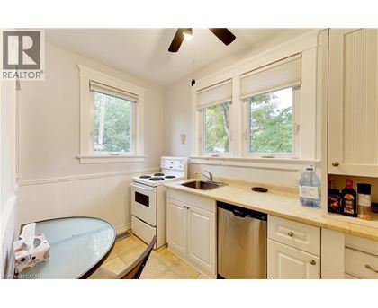 A small kitchen with a stove, sink, and window.
