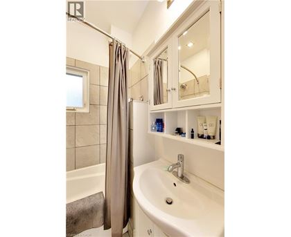 A white bathroom with a white tub and sink.