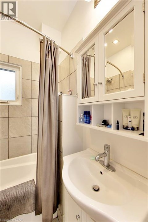 A white bathroom with a white tub and sink.