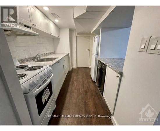 A kitchen with a stove top oven and a window overlooking the ocean.