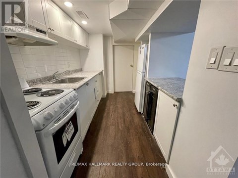 A kitchen with a stove top oven and a window overlooking the ocean.