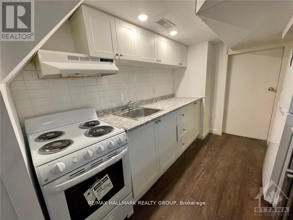 A kitchen with a stove top oven and white cabinets.