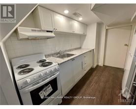 A kitchen with a stove top oven and white cabinets.
