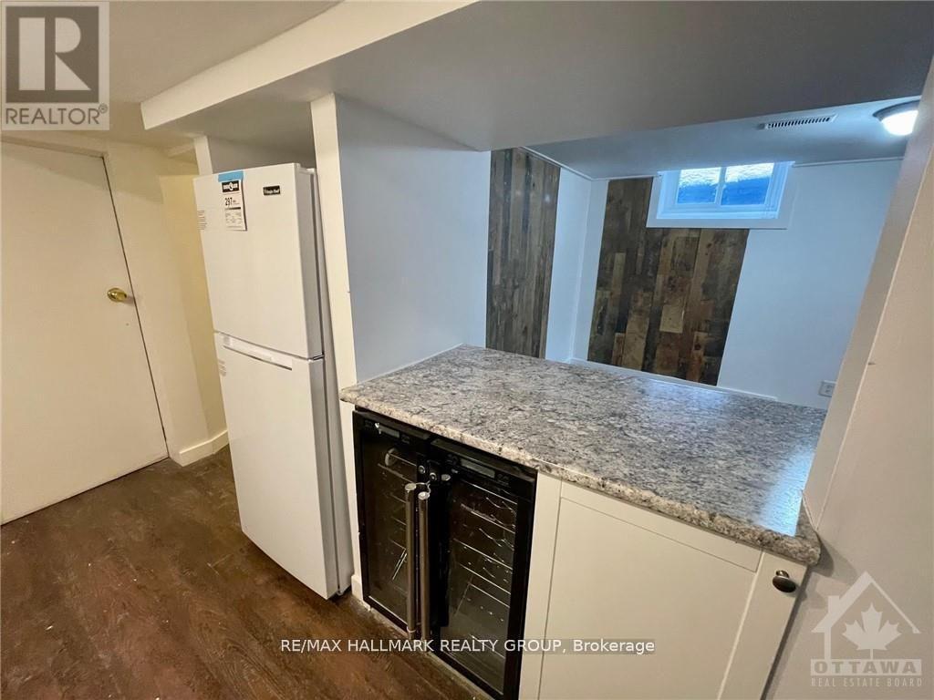 A kitchen with a white fridge and a granite counter top.